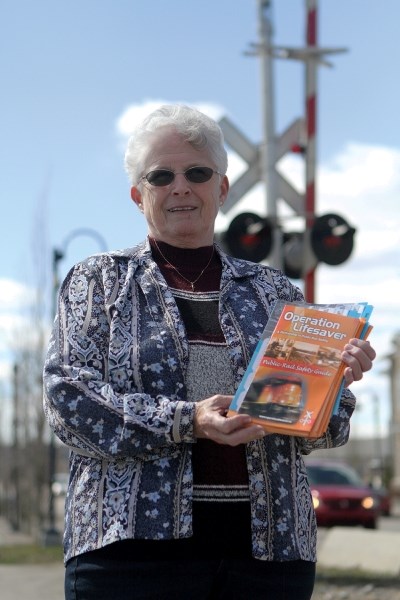 Rail safety advocate Betty Melik shows off Operation Lifesaver information at the crossing on 1st Avenue in Airdrie during last year&#8217;s National Rail Safety Week.