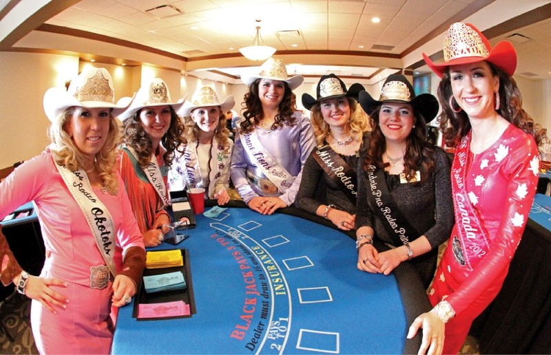 (Fifth and sixth from the left) Miss Rodeo Airdrie Gillian Shields and Airdrie Pro Rodeo Princess Rebecca McKay pose for photos at a blackjack table during the Airdrie Rodeo