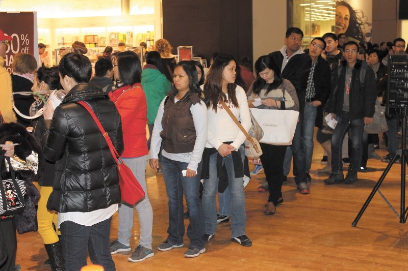 Shoppers waited in line to get into the Coach designer handbag outlet store on Boxing Day as they tried to get a deal at CrossIron Mills on Dec. 26, 2013.