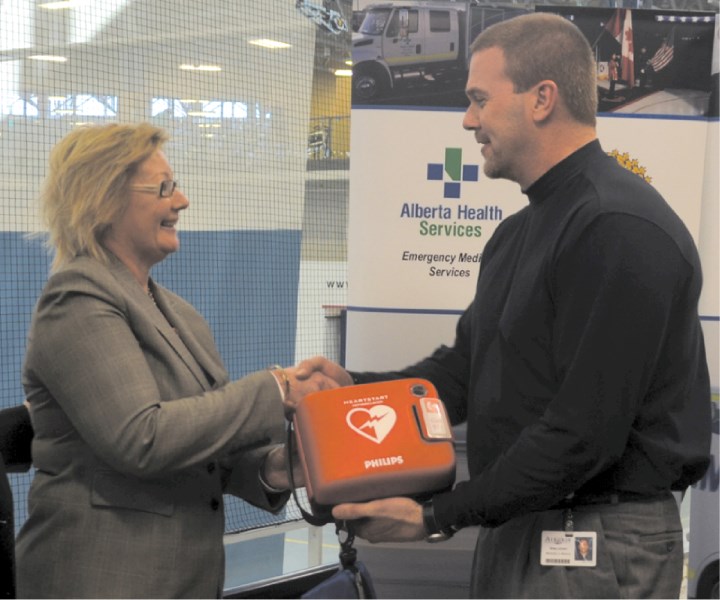 EMS Foundation Executive Director Lisa Barrett presents Genesis Place Manager Greg Lockert with a new defibrillator, Feb. 5 at Genesis Place.