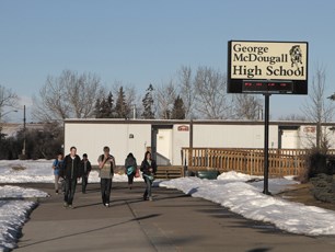 Students rush to get to their classes in portables at George McDougall High School, March 13.