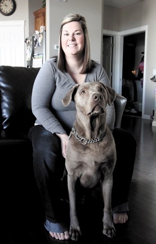 Sonya Young, and he dog Gretzky, pose for a photo at her Luxstone home, March 20. Gretzky suffered injuries after being attacked at Nose Creek Park last month.