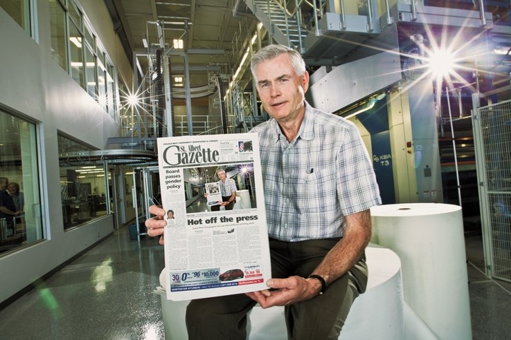 CEO of Great West Newspapers Duff Jamison holds one of the first newspapers off the new press in St. Albert in June.