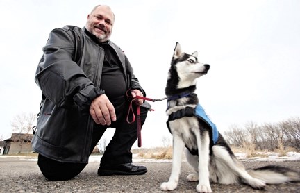 Don Leonardo, a veteran of the war in the former Yugoslavia, plays with his new service dog Diesel outside trainer Donna Luchak&#8217;s Okotoks home. Diesel was a rescue dog