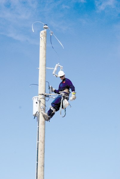 A FortisAlberta lineman works to restore power to customers. Outages can now be reported to the company via its mobile app.