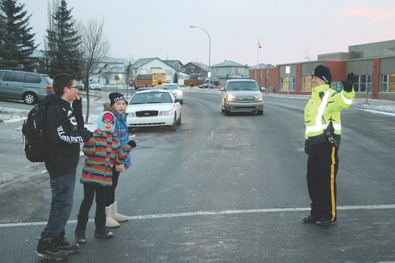 Cst. Meagan Fillion showed students Michael Hennelly, 12, Katrina LaManne, 8, and Gabriella LaManne, 11, the right way to cross the street outside Good Shepherd School.