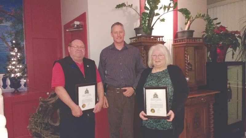 David Martin (left) and Sandra Broderick (right), member of Airdrie Citizens on Patrol, were presented with a special award of recognition by Inspector Gordon Sage (middle)