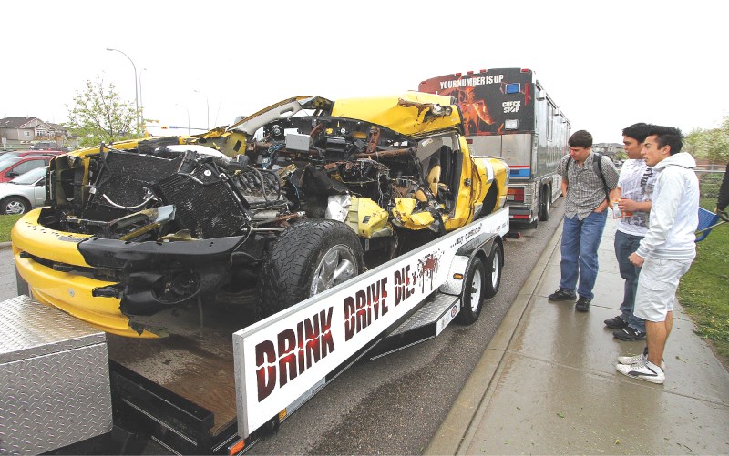 Students from St. Martin de Porres High School check out the remains of a truck that was involved in an accident, caused by a drunk driver, during the school&#8217;s first