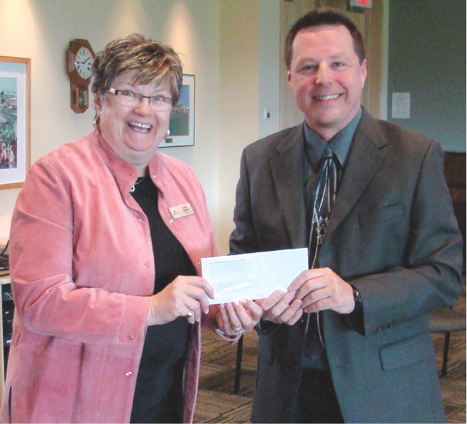 Rocky View Schools Board Chair Sylvia Eggerer accepts a $13,000 cheque from Bruce Daniels, general manager of The Range FM, June 3. The radio station is donating the money