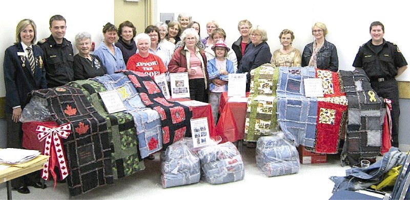 Crossfield Operation Peace and Comfort members pose with their completed quilts, June 14.