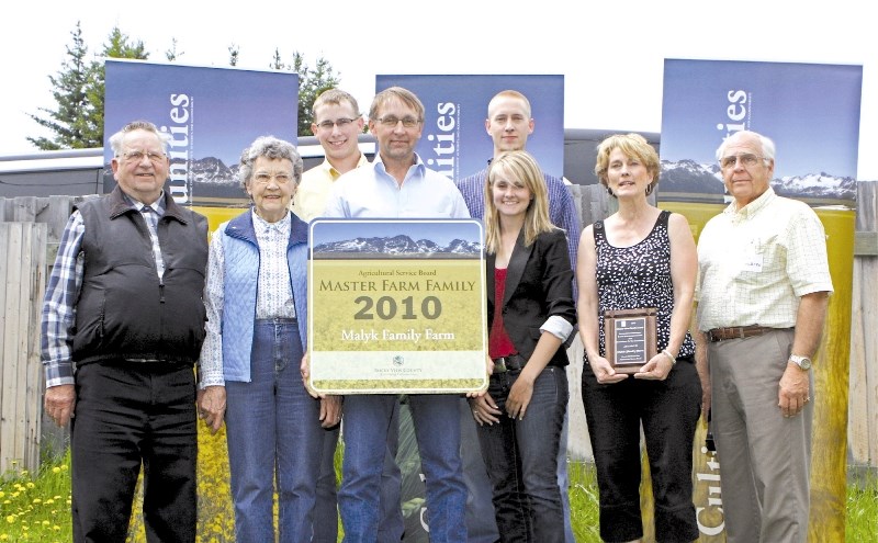 (Left to right) Lloyd, Kay, Matthew, Gary, Ben, Erin and Debbie Malyk pose for photos with Earl Solberg of Rocky View County after accepting the 2010 Master Farm Family award 