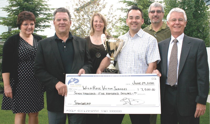 Wild Rose MP Blake Richards, and representatives of area victims&#8217; assistance groups, accept a donation of $7,500 from Larry Bohn (far right) of the Bow Valley Credit