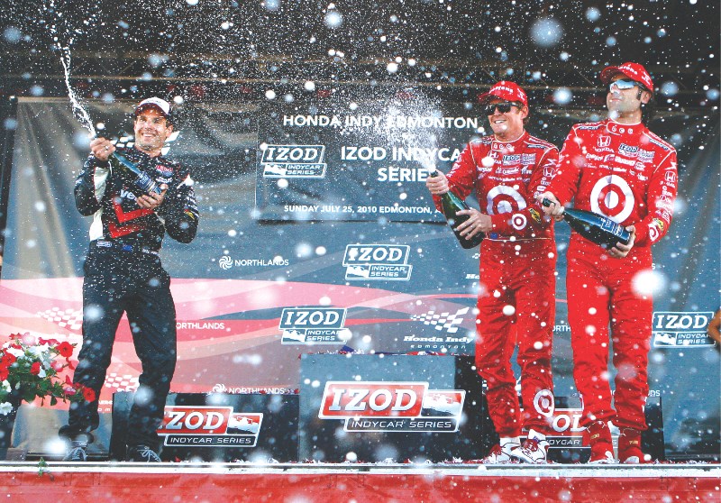 (Left to right) Runner up finisher Will Power, race winner Scott Dixon and third place finisher Dario Franchitti celebrate on the podium with a champagne shower at the