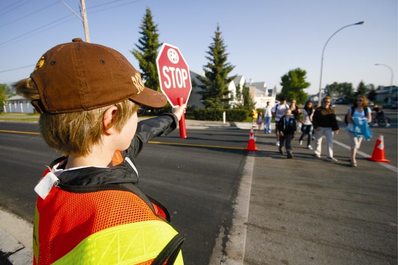 Crossing guard Hayden Goodall, 10, helps parents and students across the street, the first day of school at Ralph McCall school in Airdrie, Aug. 19. Drivers are urged to use