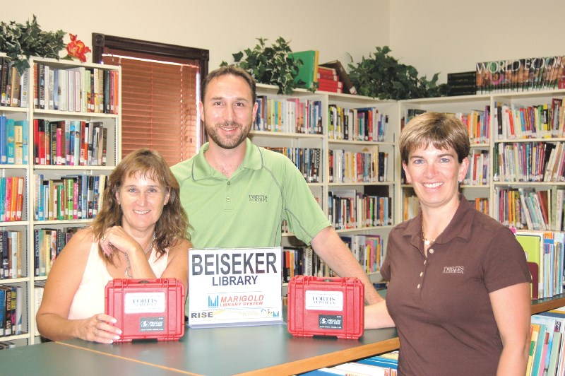 Beiseker librarian Tracy Bell (left) accepts two new power monitors donated by Fortis representatives Kevin Haslbeck and Joelle Lamontagne (right), Aug. 25. The monitors are