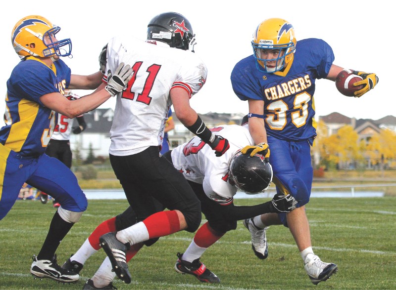 Bert Church Charger running back Brandon Fuchs knocks aside Chestermere tackler Mike Lucyshyn, Sept. 24. Fuchs had three touchdowns in his team&#8217;s 42-0 victory.