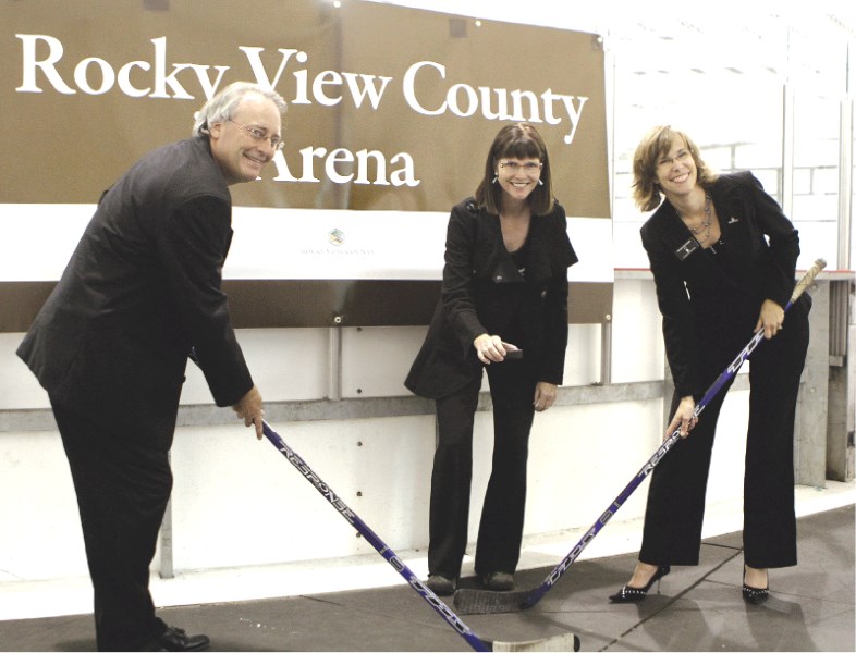 Paul McDonald, with the Chestermere Recreation Board, Rocky View County Reeve Lois Habberfield and Chestermere Mayor Patricia Matthews hold a mock puck drop for the media