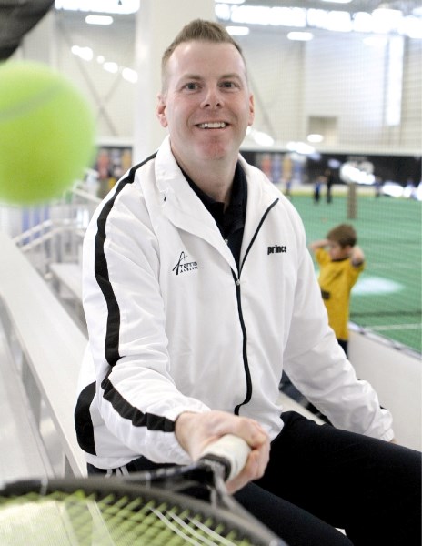 ADTA president Chris Simnett, Tennis Alberta&#8217;s 2010 Volunteer of the Year, poses with his racket at Genesis Place, Nov. 27.