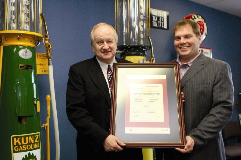 Measurement Canada President Alan Johnson presents certification to Cantest Solutions Inc. Director Adam Morand, Nov. 25. The Airdrie business now has the authority to
