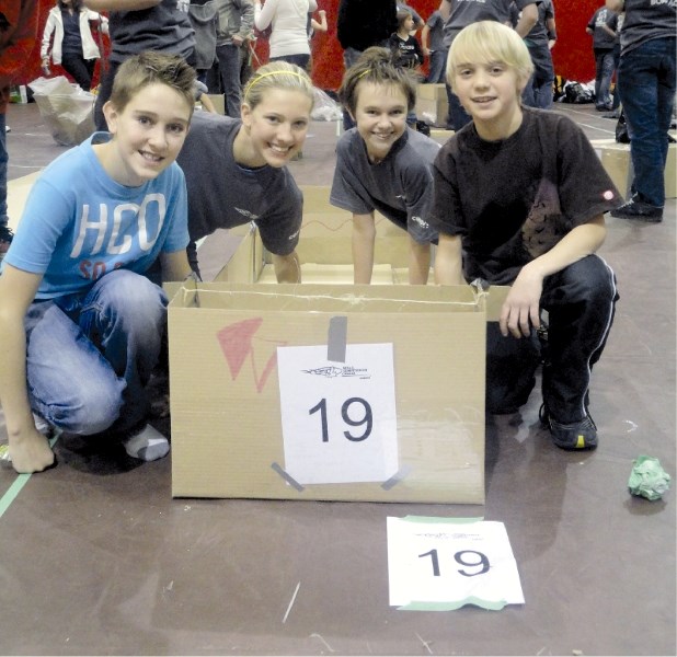 (Left to right) Liam Russell, Kalbie Holkanson, Tahnee Harder and Mark Madge pose for photos with their championship-winning cardboard boat at SAIT, Nov. 24.