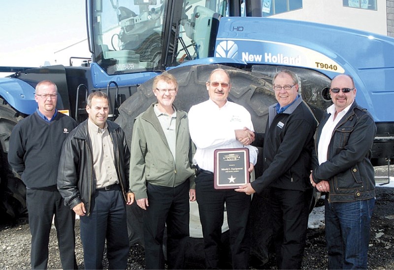 (From left to right) Kyle Jensen, Dale Belsher, John Mathison, Cyd Gyug, Doug Warner and Norm Tipton pose with their award from New Holland Agriculture, April 20. The