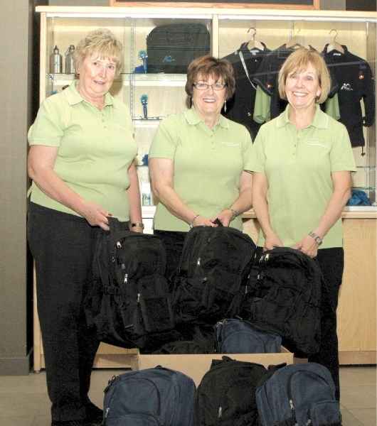 (Left to right) Telus Community Ambassadors Lesley Ritchie, Wendy Hoflin and Lynn Nielsen pose with just some of 150 backpacks, filled with supplies, delivered to Rocky View