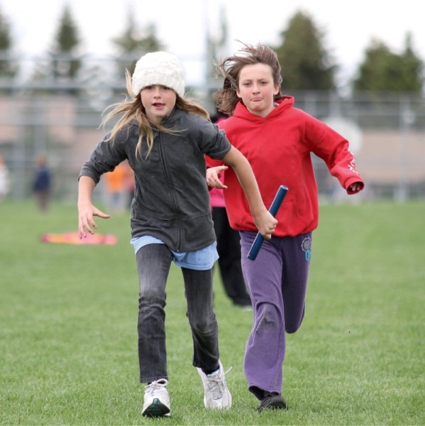 A.E. Bowers&#8217; students Maddy McKinley (left) and Madison Turley practice their 4&#215;100 metre relay during recess at the school, June 15.