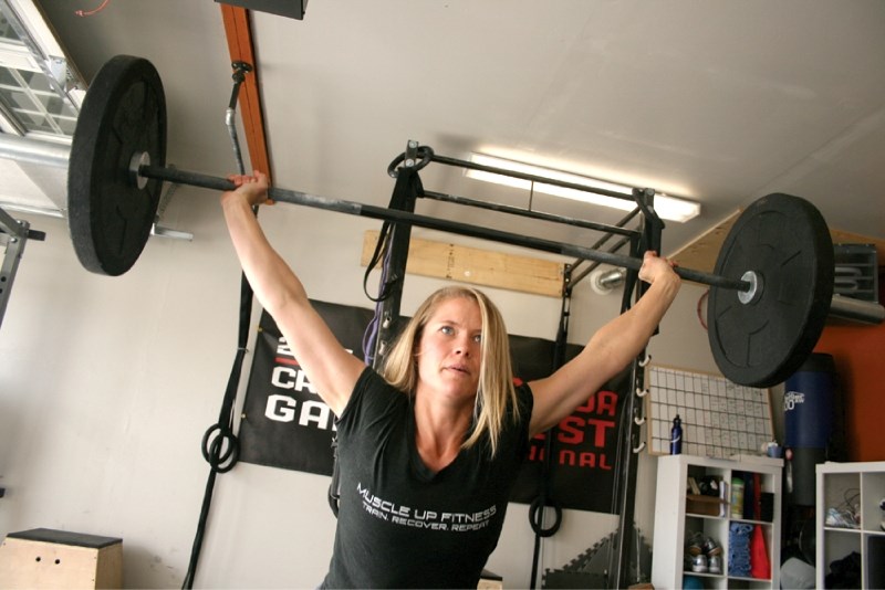 Heather Crippen works out in her home gym, which doubles as her home-based business, on June 17. The mother of two young children placed 14th at the Canada West CrossFit