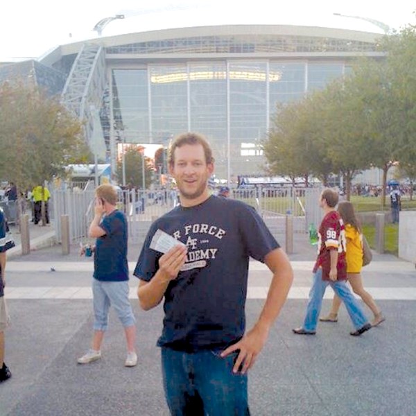 Reporter Nick Kuhl shows off his tickets to Monday Night Football in front of Cowboys Stadium in Arlington, Texas, Sept. 26.
