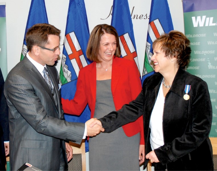 Global Television&#8217;s Bruce McAllister shakes hands with Heather Davies, former Wildrose candidate, while Danielle Smith leader of the Wildrose party looks on at
