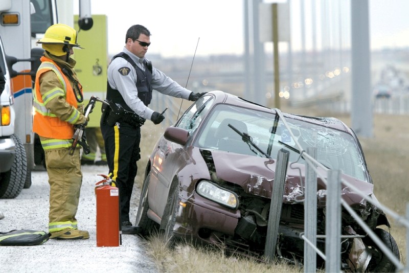 Const. Craig Murray smashes out the front window of a car that collided with the safety cables along Highway 2 at about 11 a.m. Nov. 15. The driver sustained minor bumps and