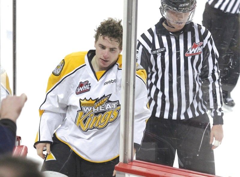 Cochrane&#8217;s Jason Swyripa gets escorted to the penalty box after his fight with Greg Chase during the Brandon Wheat Kings&#8217; 4-3 loss to the Calgary Hitmen at the