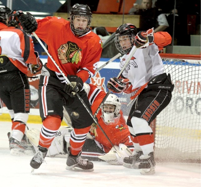 UFA forward Tyler Wong, a standout with the Airdrie Xtreme last season, battles for position with Blackhawks defenceman Ryan Pilon, during the Bisons and Beardy&#8217;s 1-1