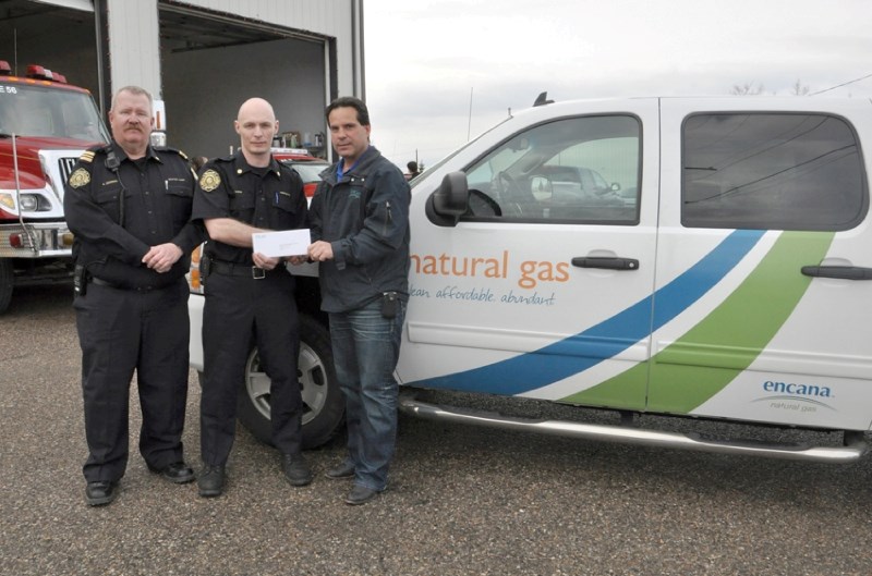 Station 56 Chief Kelly Saunders and firefighter Shane Dixon receives a $20,000 cheque from Larry Marshall, community relations advisor for Encana.