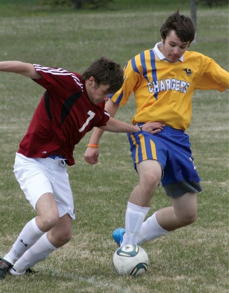 Cochrane Cobra Stephen Shevas tries to keep the ball in bounds and away from his Bert Church opponent during a home game, May 10.