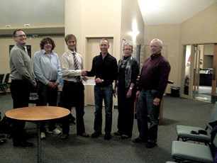 Gord Clayholt of TransCanada Pipelines presents a $10,000 cheque to Crossfield council during the March 5 meeting. The money will be used for the Town&#8217;s Highway 2A Berm 