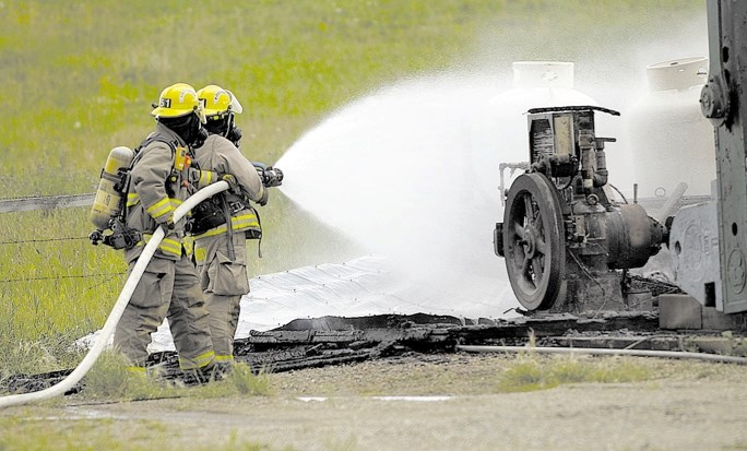 Fire crews work to extinguish a blaze at an oil pumpjack near Bearspaw.