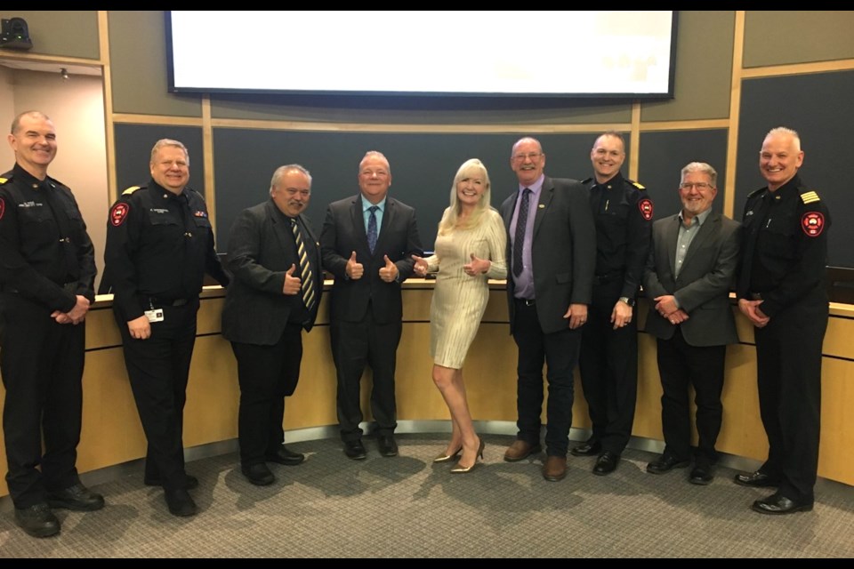 Tracy Osborne poses alongside members of Airdrie City Council and the Airdrie Fire Department during a council meeting on March 7.