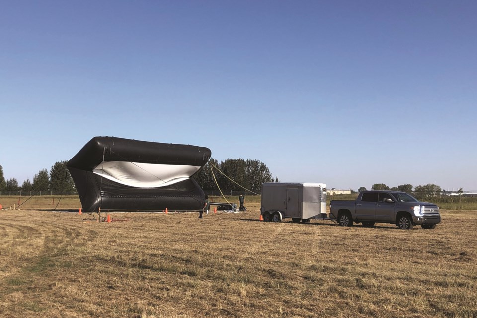 Fresh Air Cinema is pictured setting up an inflatable screen for a drive-in movie showing held last summer at the Crossfield Rodeo grounds.