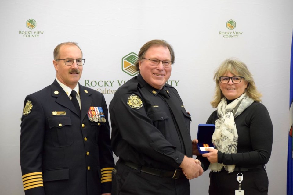 Clark Graham (centre), a volunteer fire fighter in Langdon, receives a Fire Services Exemplary Services Award for 30 years of service. To his left is RVC Fire Chief Ken Hubbard, and to his right is RVC Division 3 Coun. Reeve Crystal Kissel.