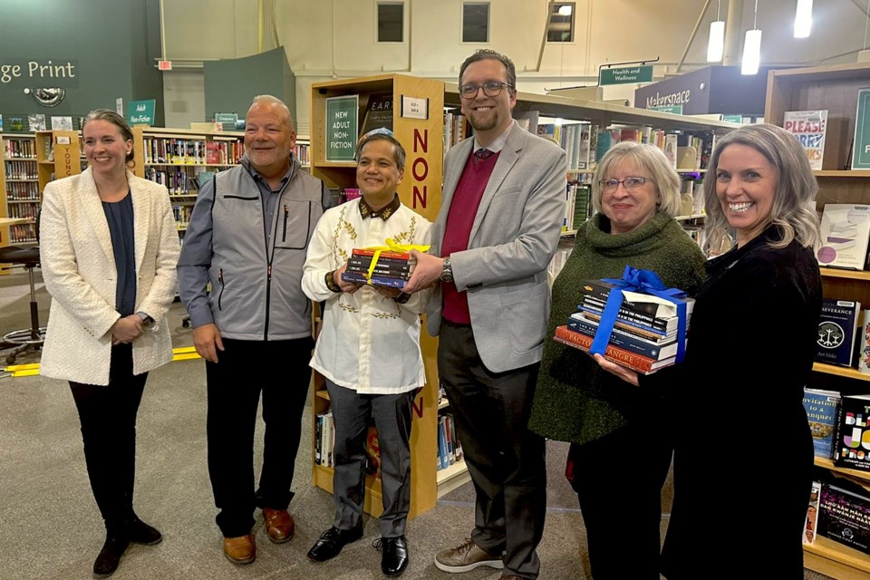 From left, Deputy Mayor Tina Petrow, Mayor Peter Brown, Philippines Consul General Zaldy Patron, APL Board Chair Daniel Nelles, APL Board member Catherine Bucannon, APL Director Deb Cryderman, receive books in both English and Tagalog on the Philippines and on the Knights of Rizal founder, Dr. Jose Rizal. They will be added to the library’s collection.