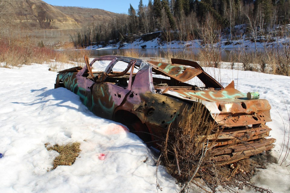A wrecked and rusted car left along the Beatton River north of Fort St. John.