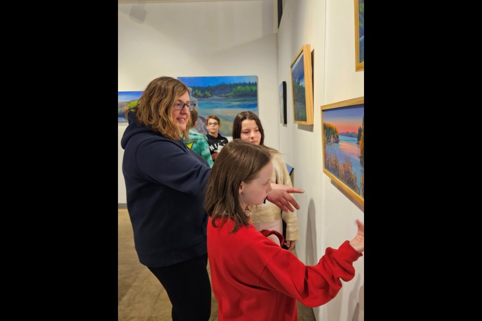 Newth leads students through the collection on the walls. 
