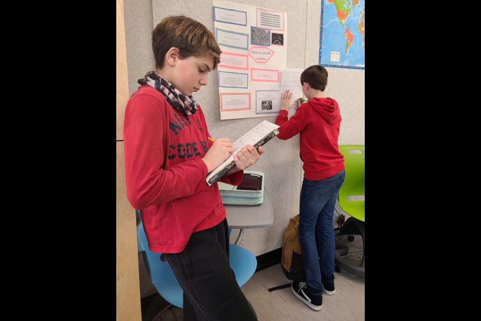 Preston Dunning judges a Money Fair project at Dr. Kearney middle school on March 16, 2023.