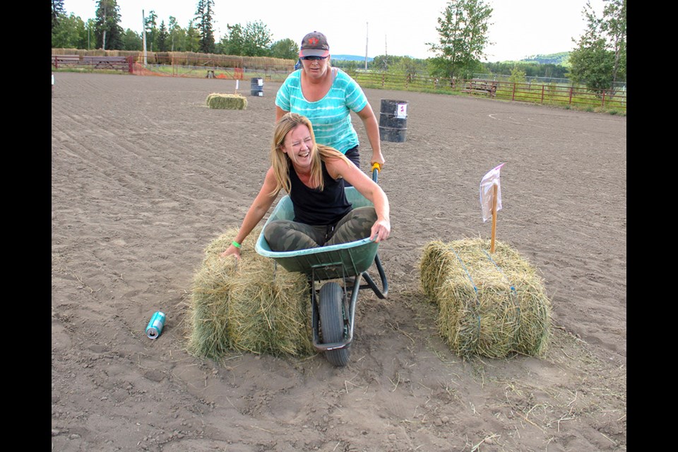 Amanda Brown, sitting inside the wheel barrow, has to tell a blindfolded Shona Duff how to manoeuvre the obstacle course.