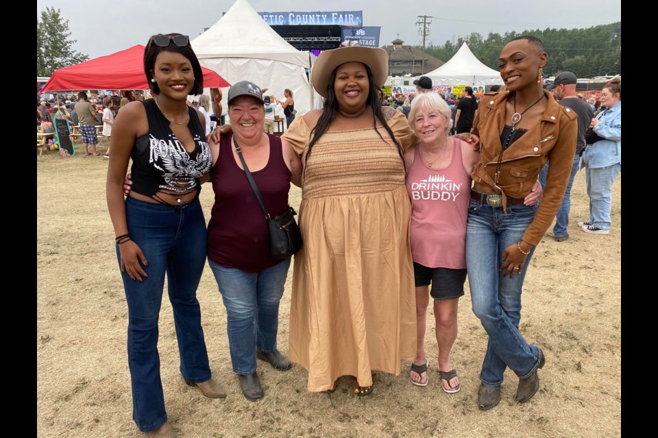 Joan Robertson and Carol Arsenault, locals of Fort St John got their photo taken with the members of Chapel Hart at the Energetic County Fair.
