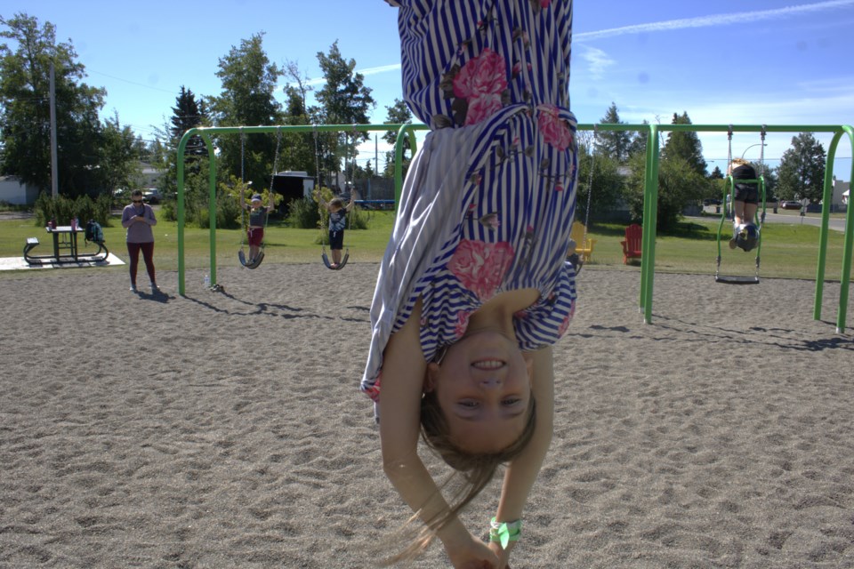 Hanging upside on the bars at Tot Lot Park is 9-year-old Ellia Martin of Fort St. John. July 20, 2022