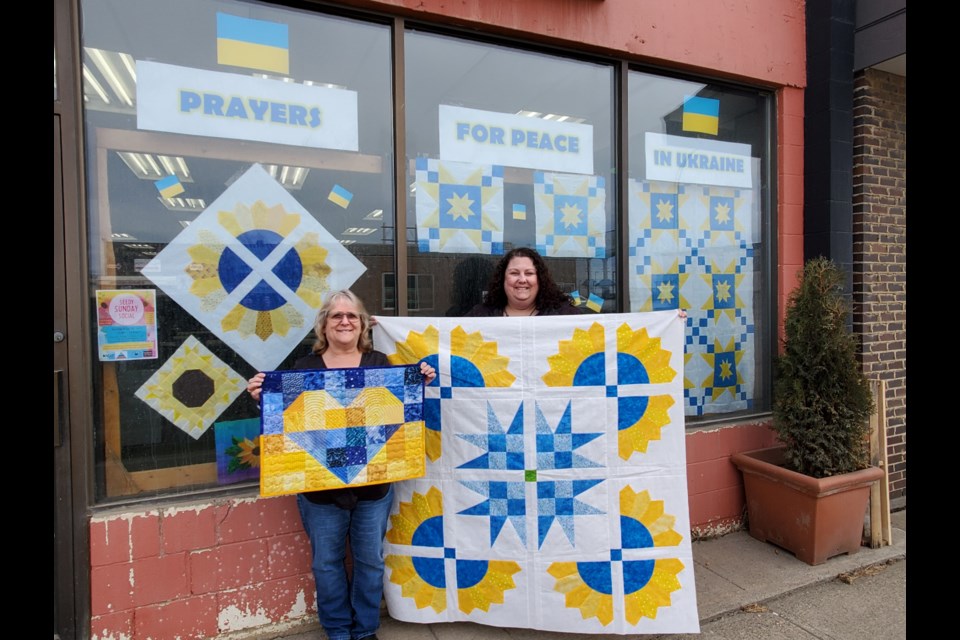 FSJ Country Quilter's Guild Secretary Donna Gauthier and Vice President Lisa Babuick at their downtown display at the Fireweed Market. 