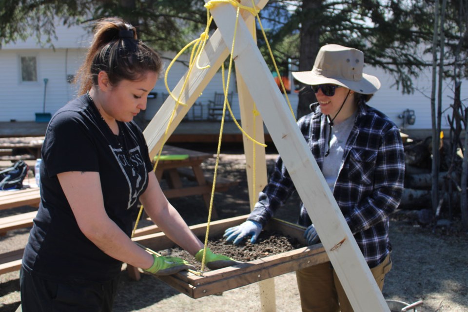 Prophet River First Nation member Tamara St. Pierre and UNBC student Taylor Orton carefully sift through soil to look for flakes and fragments of bones and stone tools. 