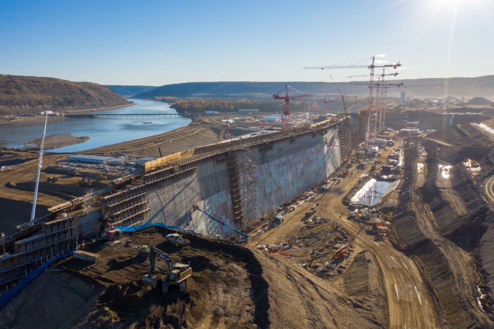 Roller-compacted concrete ramps are removed from the dam core buttress, and insulation is installed on the upstream side of the buttress